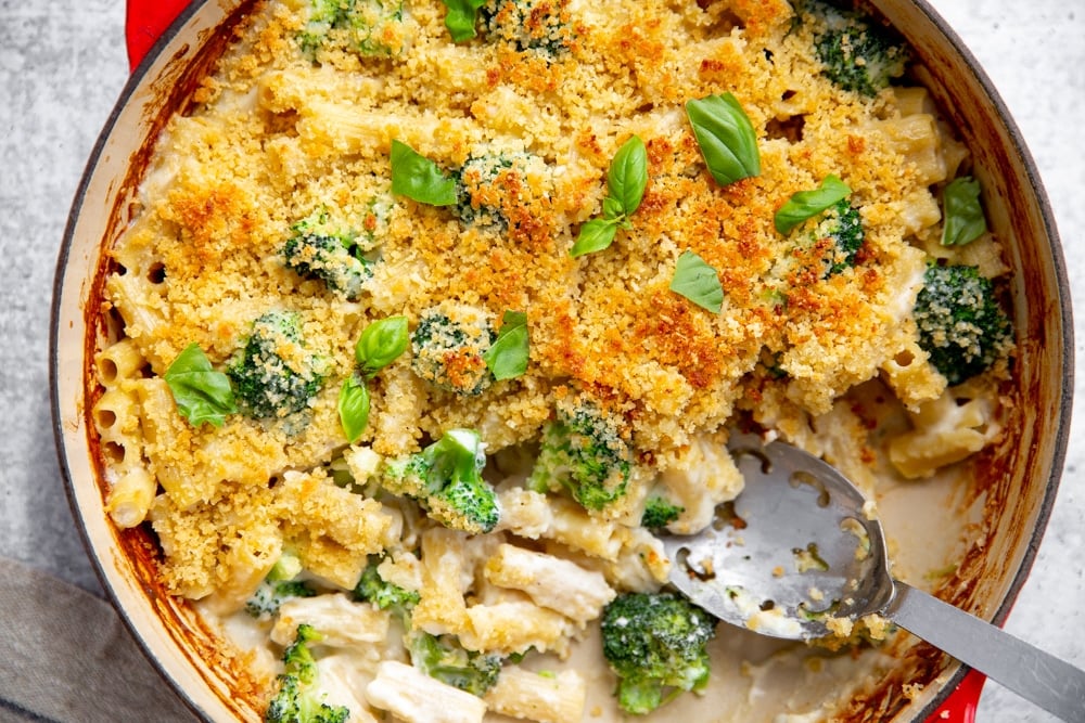 Close up of a skillet of baked pasta with a serving spoon. 