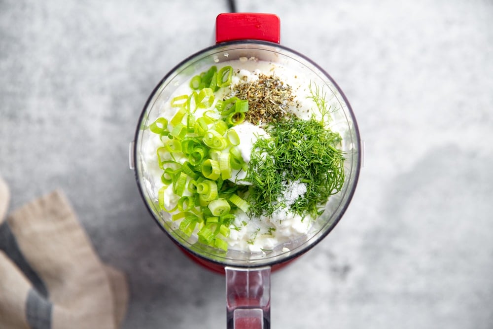 Process shot showing all of the dip ingredients in a mini food processor. 