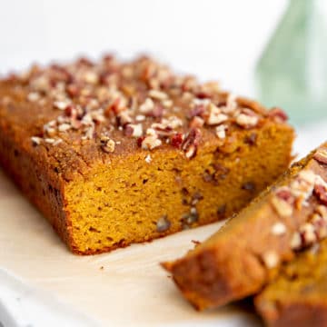 Close up of a loaf of healthy pumpkin bread on a serving board.