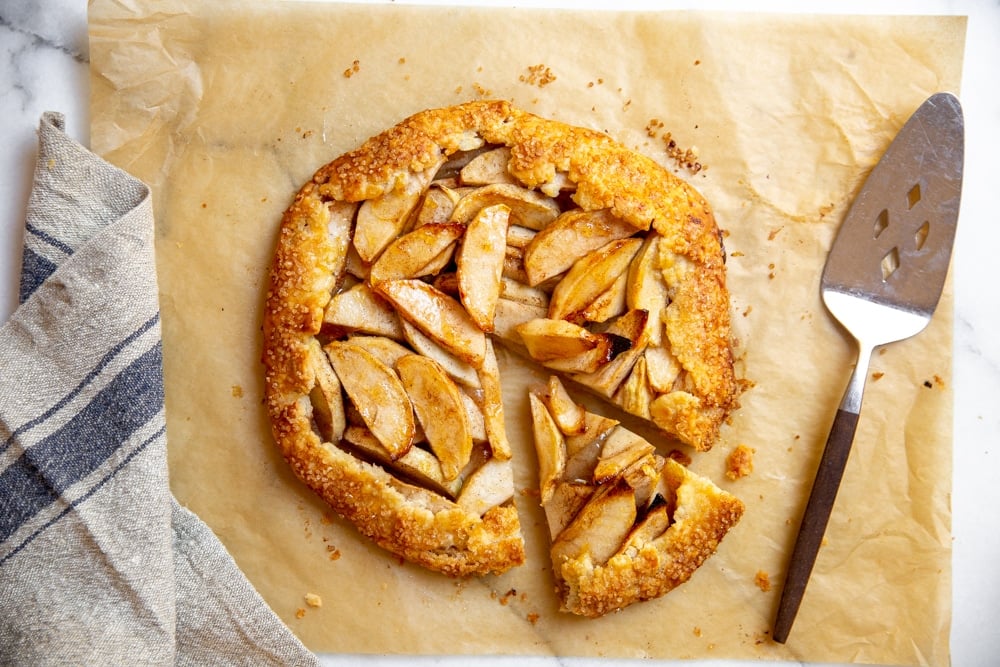 Baked galette on a piece of parchment paper, with a pie server alongside. 