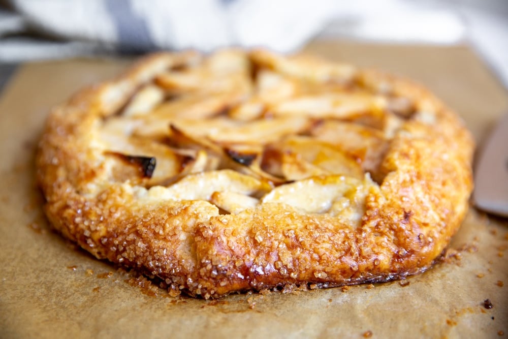 Close up of the baked apple galette on a parchment lined baking sheet. 