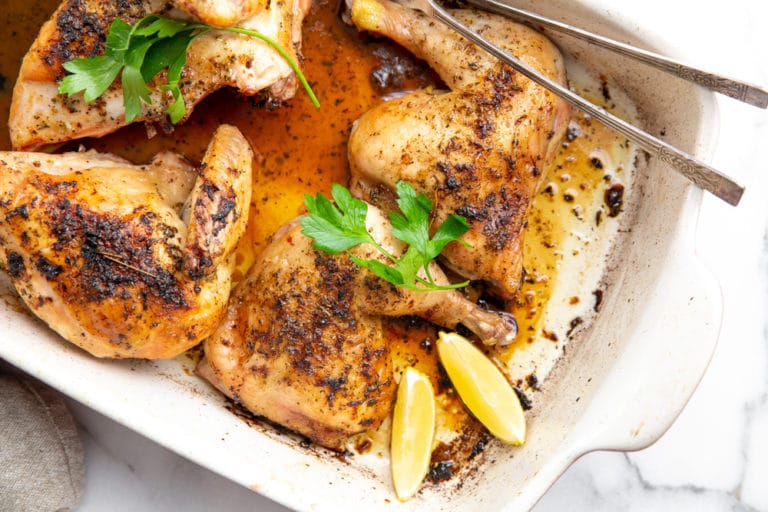 Lemon garlic roast chicken in a baking dish.