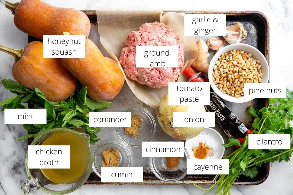 All of the ingredients for the lamb stuffed squash arranged on a sheet pan.