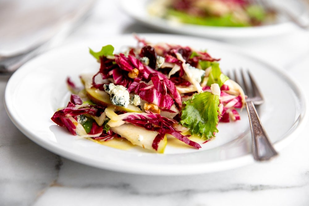 Pear and Gorgonzola salad piled on a plate with a fork alongside.