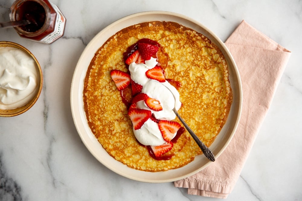 Gluten free crepe filled with strawberry jam, whipped cream and sliced strawberries.