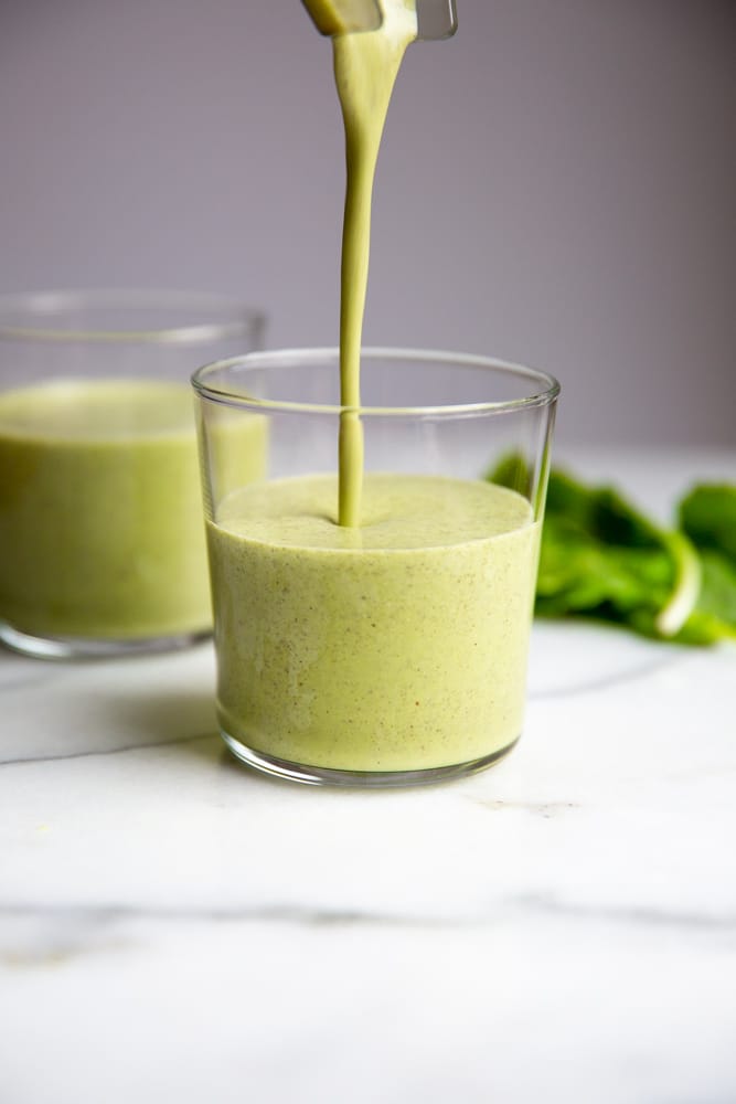 Close up of the green smoothie being poured into a glass. 