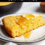 A slice of gluten free cornbread on a plate, topped with butter and honey.