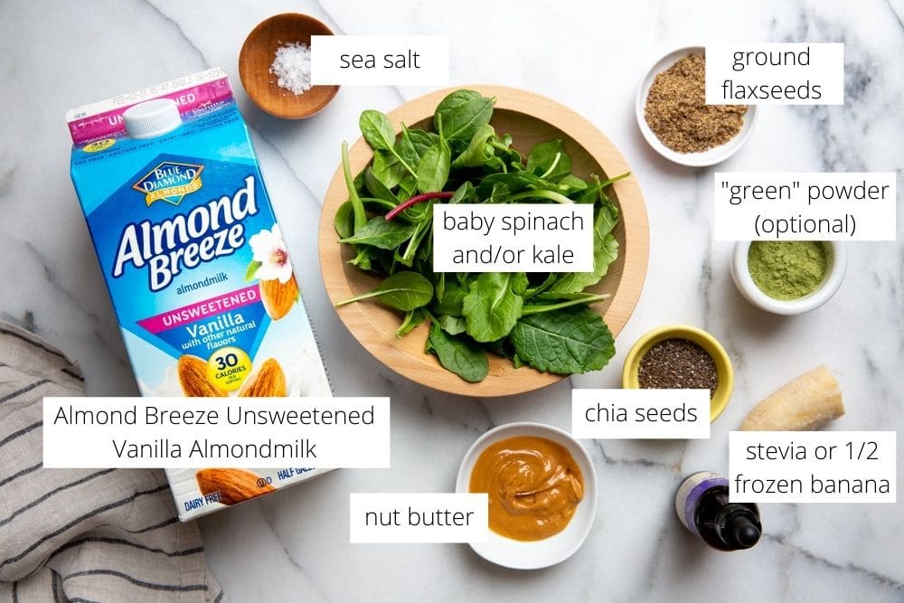 All of the ingredients for the smoothie arranged on a marble surface. 