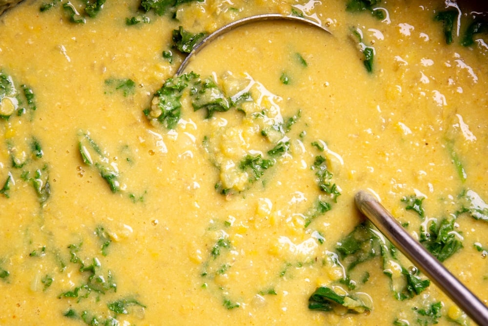 Close up of a ladle in the creamy lentil soup. 