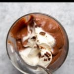 Dark chocolate pudding in a glass with a spoon.