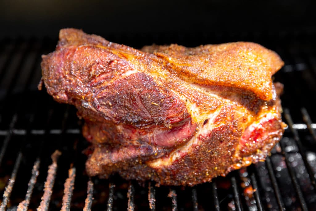 Pork shoulder on a Traeger grill after cooking.