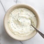 Herbed aioli in a bowl with a spoon.