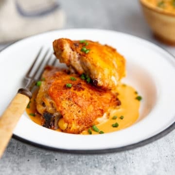 Romesco chicken on a plate with romesco chicken on the plate underneath.