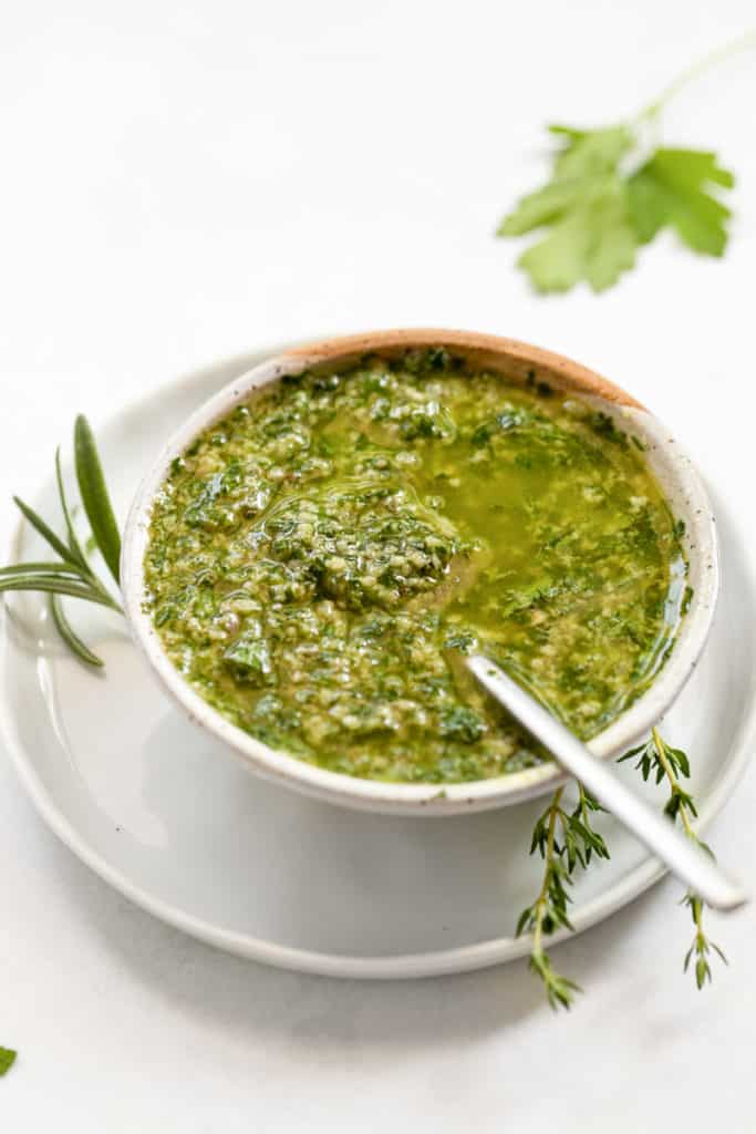 Italian salsa verde in a bowl with a spoon.