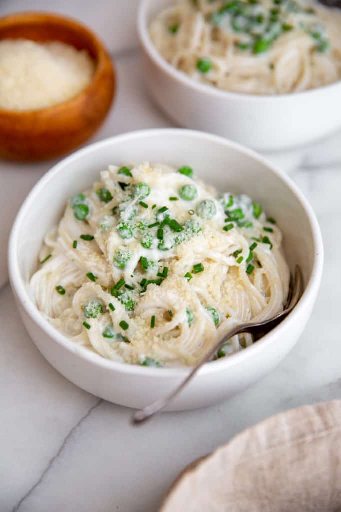 A bowl of creamy cottage cheese pasta topped with parmesan cheese and chives. 