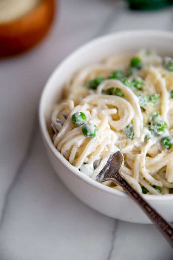 Close-up of a forkful of creamy cottage cheese spaghetti with cottage cheese sauce. 