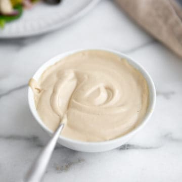 Easy tahini sauce in a bowl with a spoon.