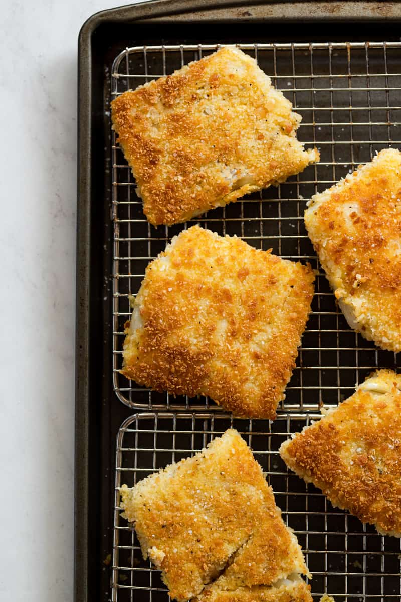 Crispy pan-fried fish draining on a wire rack to maintain crunchy exterior