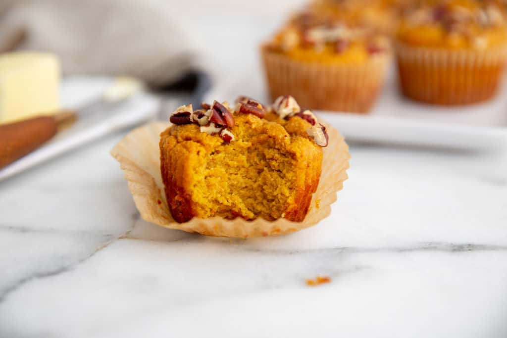 Close-up of a paleo pumpkin muffin with a bite taken out. 