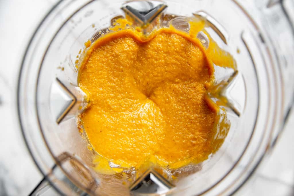 Process shot showing the pumpkin muffin batter in a blender.