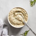Tarragon mayonnaise in a bowl with a spoon.