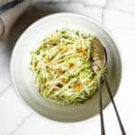 No mayo green apple slaw in a bowl with serving spoons.