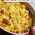 Cornbread stuffing in a baking dish with a spoon.