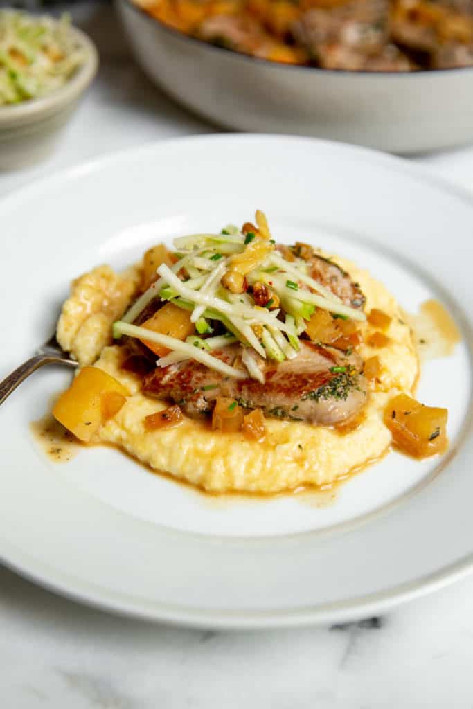 Pork and apples piled over creamy polenta, topped with an apple slaw. 