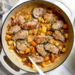 Pork tenderloin medallions and apples in a large skillet with apple cider pan sauce.