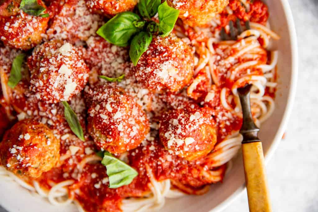 Close-up of a forkful of spaghetti and meatballs. 