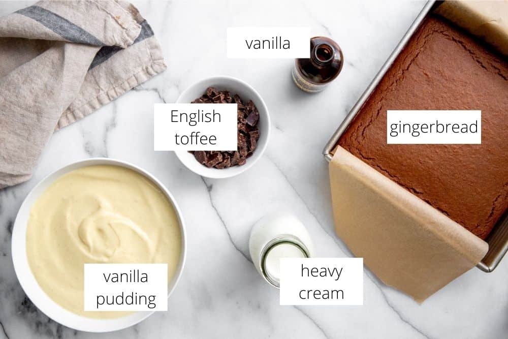 The ingredients for the gingerbread trifle recipe arranged on a marble surface with labels.