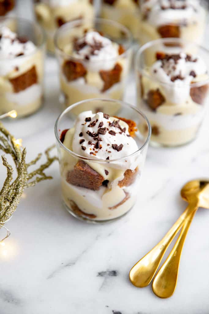 Individual gluten free trifles in serving glasses on a marble surface.