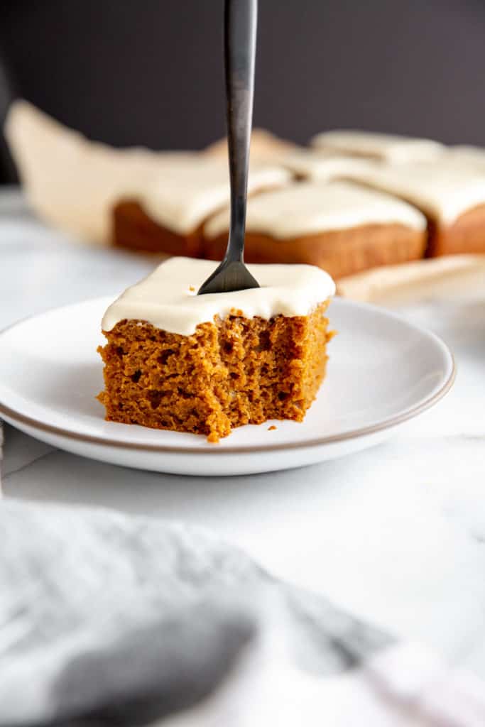Close up of a piece of gluten free gingerbread cake with a fork in the top. 
