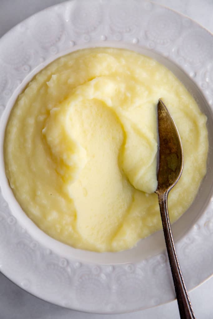Pomme puree in a bowl with a serving spoon. 