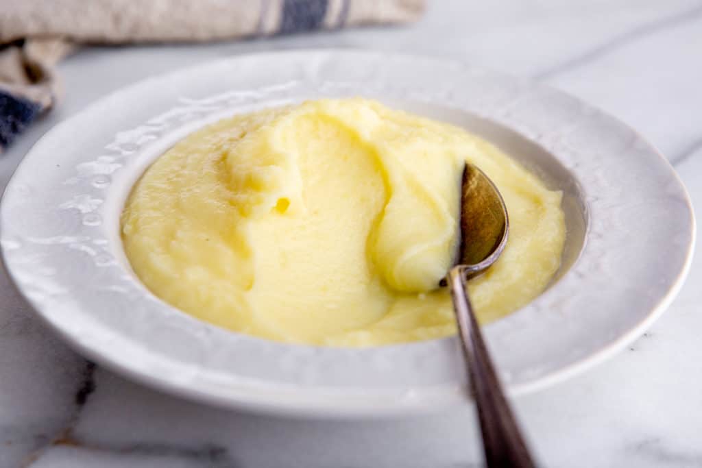 Homemade mashed potatoes in a bowl with a spoon. 