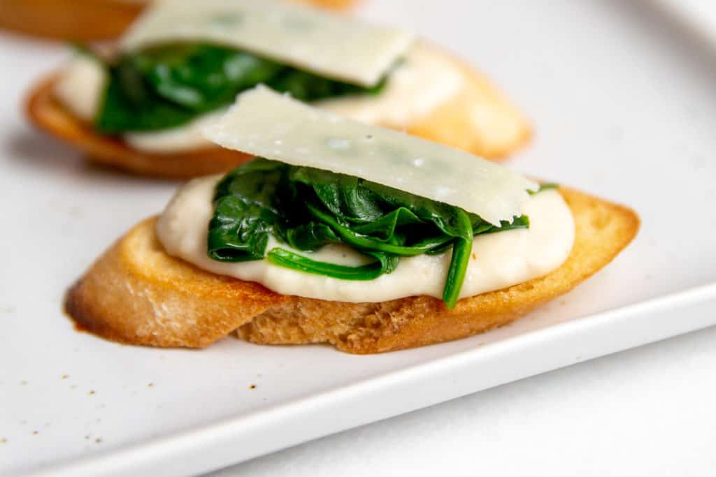 Close up of a white bean crostini on a serving platter.