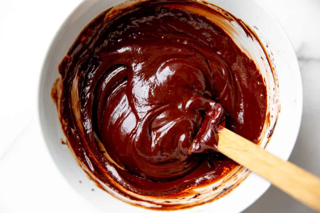 Chocolate frosting in a bowl with a spatula. 
