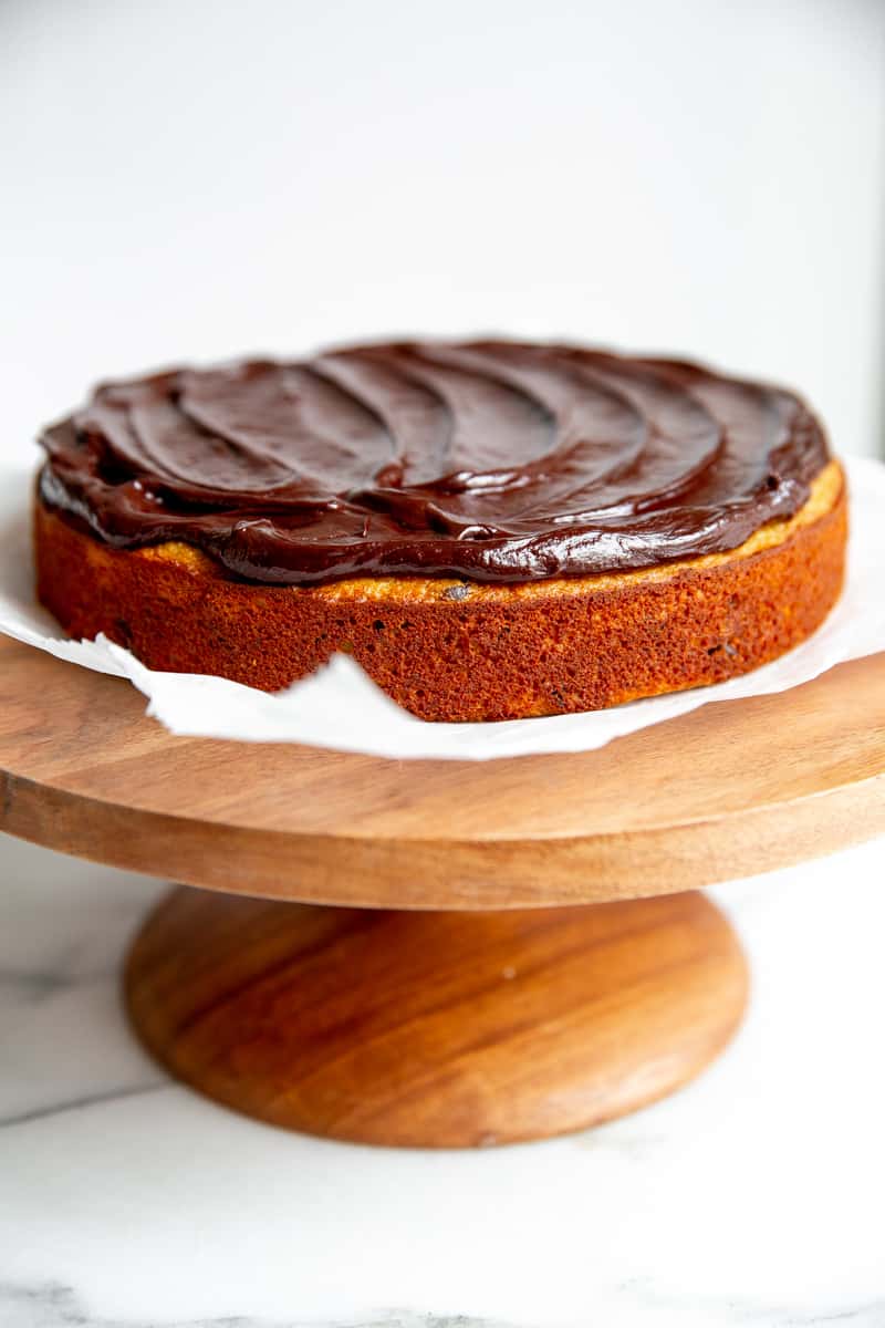 The frosted chocolate chip banana cake on a cake stand. 