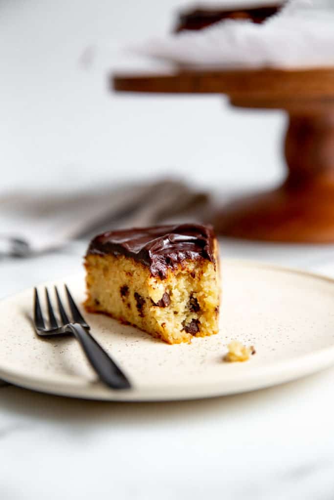 A slice of healthy banana cake on a plate with a bite taken out and a fork alongside. 