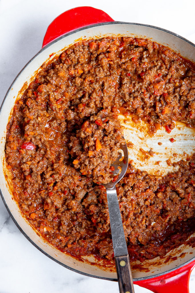 Sloppy joes in a skillet with a serving spoon. 