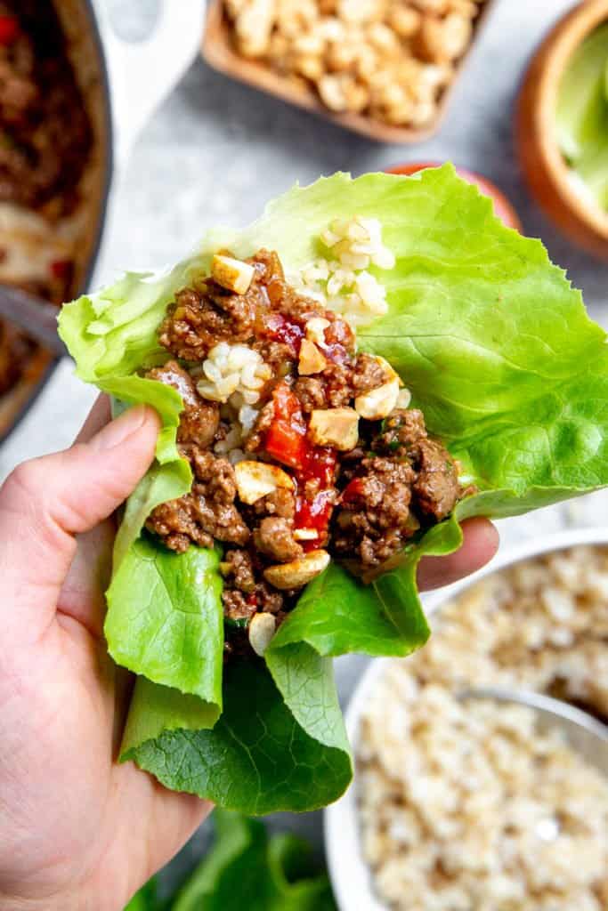 Close-up of a hand holding an Asian beef lettuce wrap. 