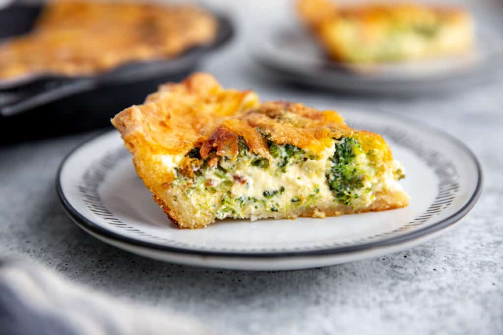 A slice of gluten free quiche on a plate. 