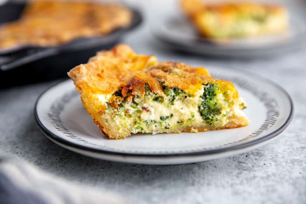 A slice of broccoli quiche on a plate.