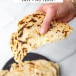 A hand holding a gluten free flatbread.