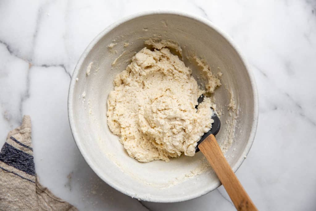 The easy flatbread dough in a bowl with a spatula.