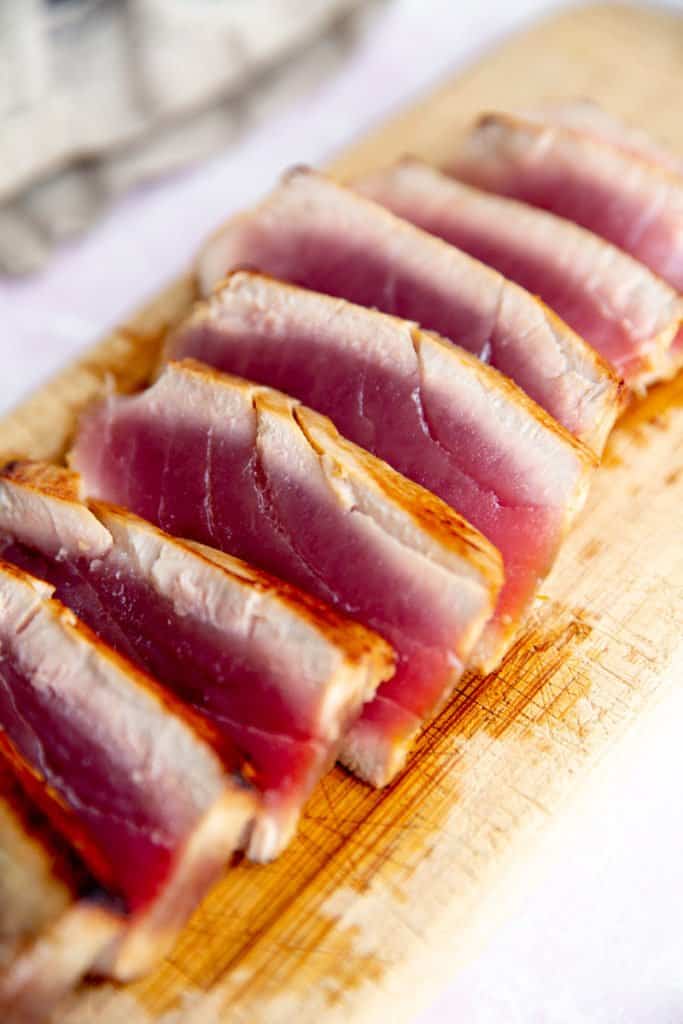 A sliced seared tuna steak on a cutting board. 