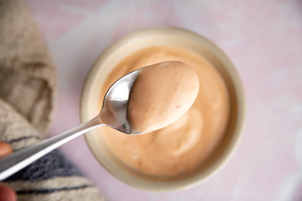 Close-up of a spoonful of sriracha mayo. 