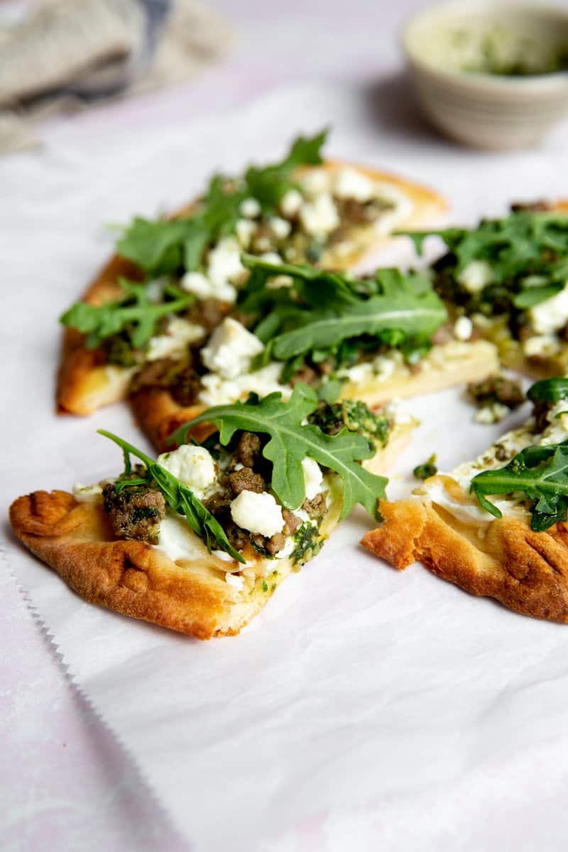 Close up of a slice of lamb pizza. 