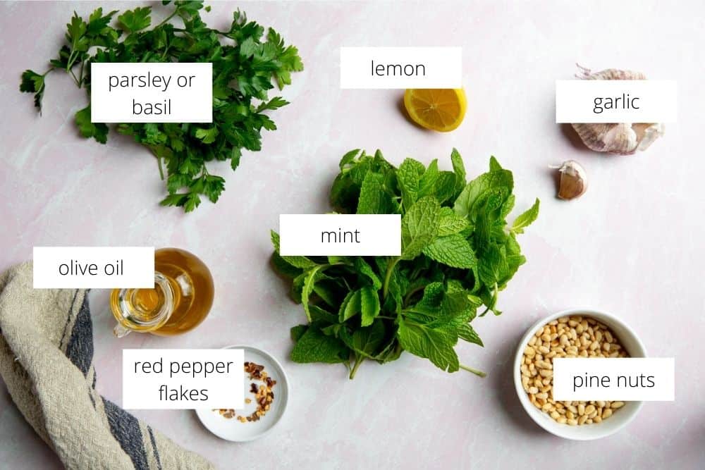 All the ingredients for the mint pesto recipe on a work surface with labels.