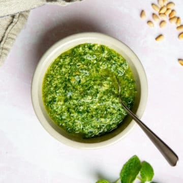 Mint pesto in a bowl with a spoon.